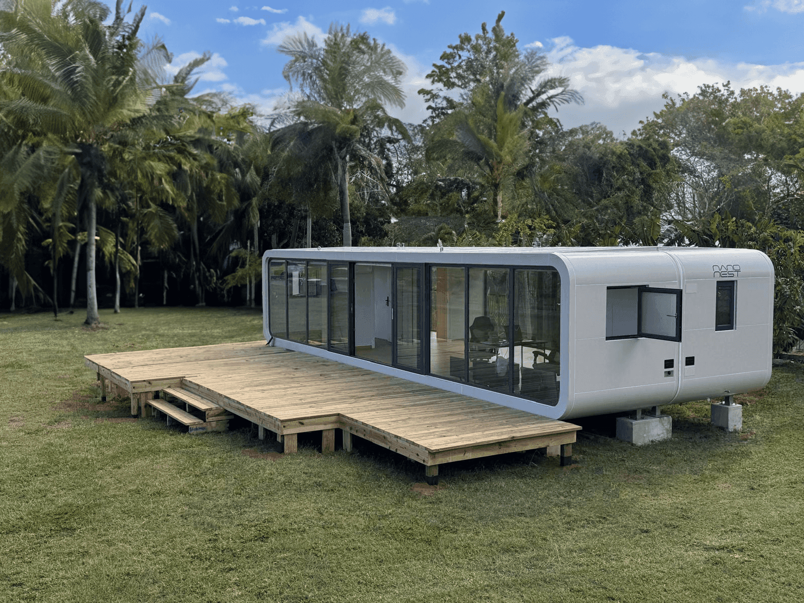NanoNest Studio Origin home on a wooden deck surrounded by palm trees
